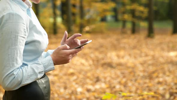 Woman talking on phone. Attractive woman talking on phone in autumn park alt