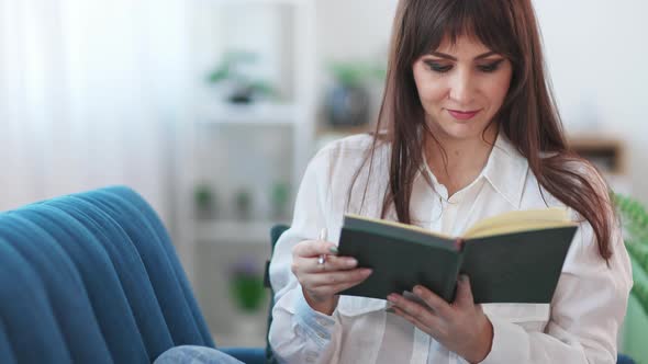 Pretty Brunette Girl Writing List in Notebook