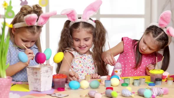 Happy Children Wearing Bunny Ears Painting Eggs on Easter Day