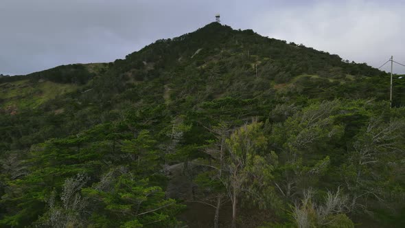 Camera capturing the hills of Pico Castelo in partial sunlight and cloud cover. alt