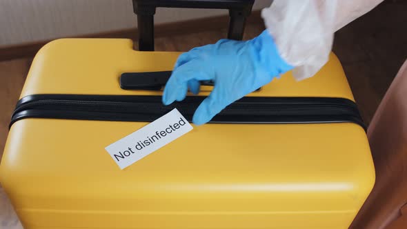 Closeup of Women's Hands Disinfecting the Surface of the Suitcase alt