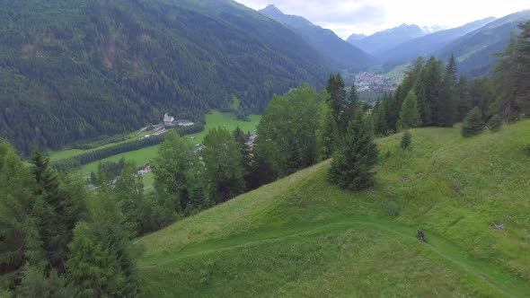 Aerial view of mountain bikers on a scenic singletrack trail alt