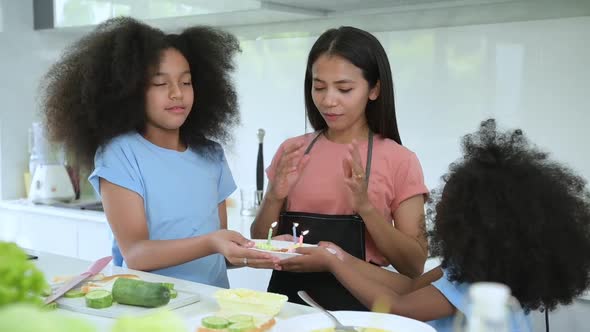 Asian-African American family Organize a birthday party for mother in the kitchen
