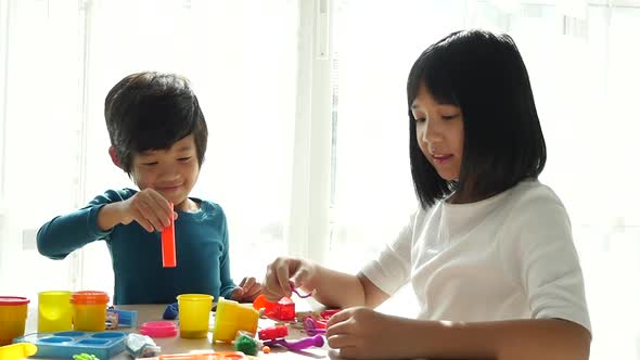 Asian Children Have A Fun Together With Colorful Modeling Clay At Home alt