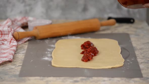 Female Hands Making Yeast Buns with Berry Jam. alt