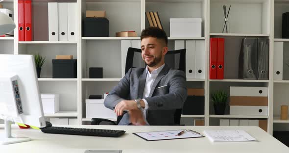 Young Businessman Spinning in Office-chair Rejoicing at Success