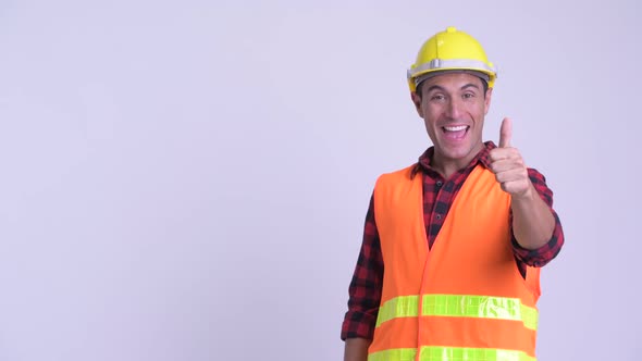 Young Happy Hispanic Man Construction Worker Touching Something and Giving Thumbs Up