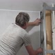 A Man Tries on a Plastic Corner When Installing PVC Panels in Bathroom - VideoHive Item for Sale