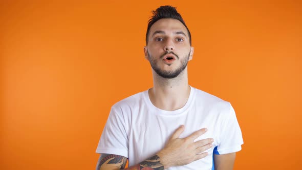 Male Football Soccer Fan Singing Hymn Hand on His Heart. Studio Shot. Patriotism Concept alt