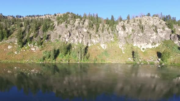 Panorama of a clear mountain lake with the landscape reflecting on the water alt