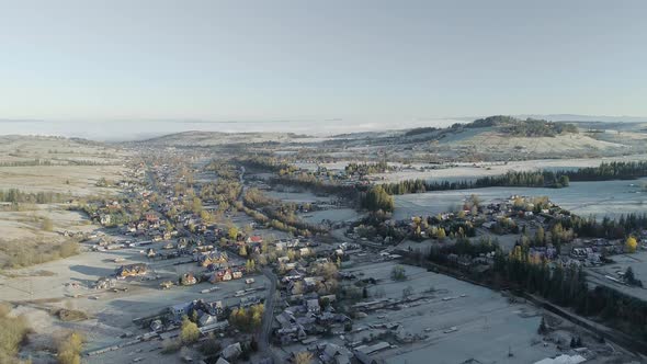Snowcapped Witow rural village and landscape, Poland. Aerial backward alt