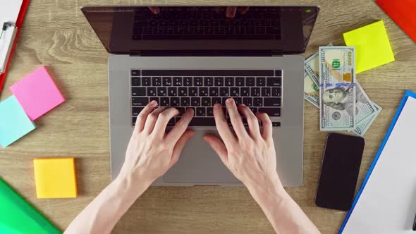 Typing Hands Using Laptop with Color Papers Phone and Money on the Table