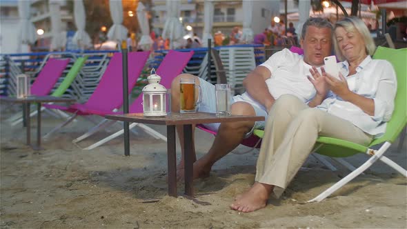 Couple with Smartphone on the Sun Lounger alt