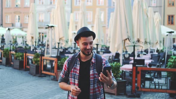 Handsome Tourist Making Video Call on Smartphone and Showing His Place of Visit alt
