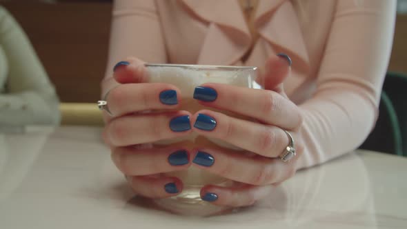Female Hands Holding Glass Cup of Hot Coffee alt
