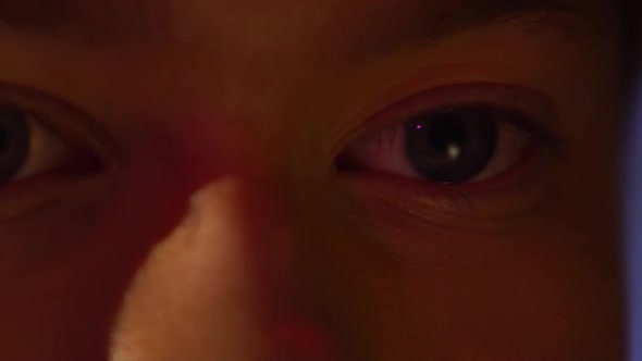 Extreme Close Up of Young Man Eyes with Projector Reflection