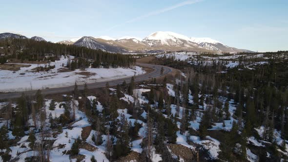 4K drone video reveal of cars driving in Rocky Mountains during winter in Colorado. alt