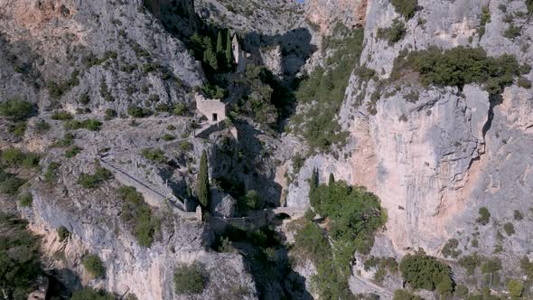 Flying towards limestone cliffs over Moustiers-Sainte-Marie village in France alt