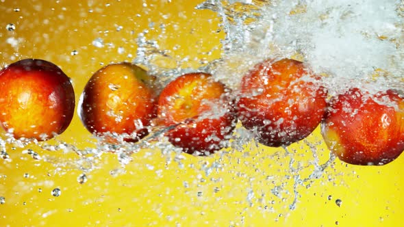 Super Slow Motion Shot of Flying Fresh Peach and Water Side Splash on Yellow Background at 1000Fps. alt