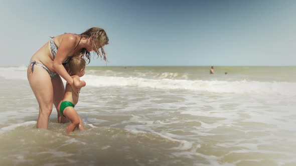 Mom Throws Her Son Up Over the Sea on Summer Vacation Under the Warm Sun alt