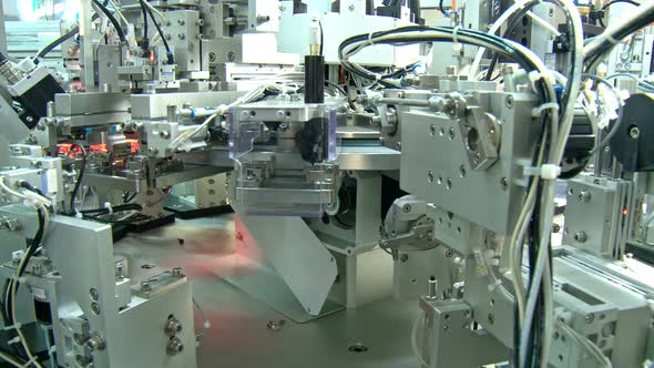 Advanced industrial production line for small parts, robotic arms working alt