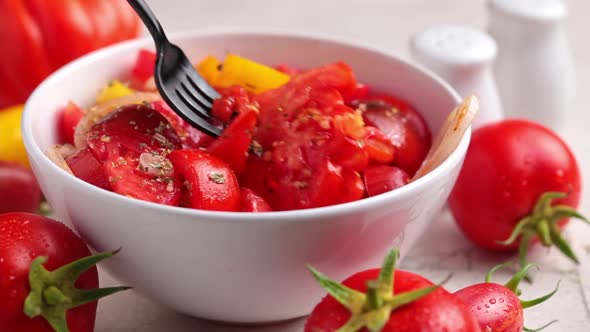 Summer tomatoes and onion salad in a white bowl alt