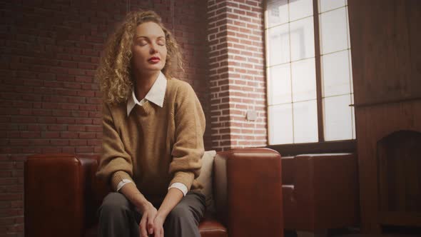 Portrait of a Confident Curly Blond Woman in a Loft Apartment alt