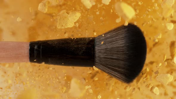 Super Slow Motion Shot of Makeup Brush and Golden Powder Explosion at 1000 Fps alt