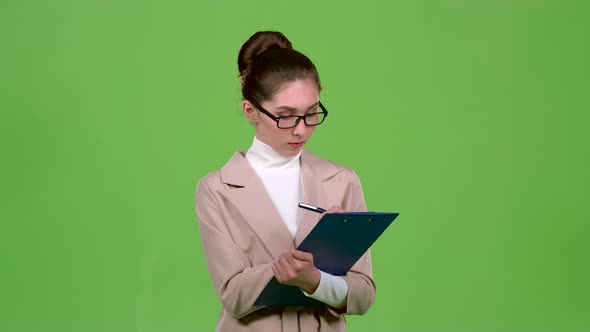 Manager Fills the Questionnaire with a Pen on a Paper Tablet. Green Screen. Slow Motion alt