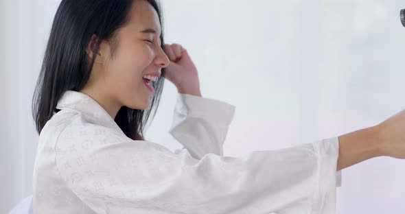 Asian beauty blogger live streaming talking with fan by action camera on the bed