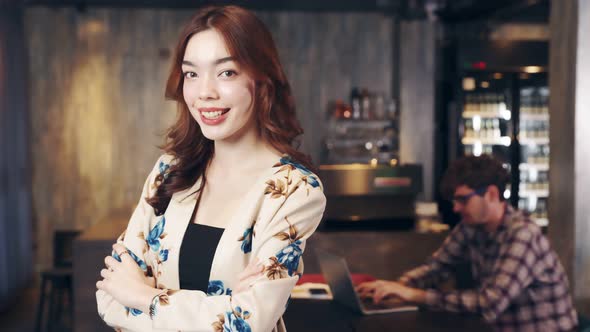 Business owner attractive young asian woman in apron hanging we're open sign. alt