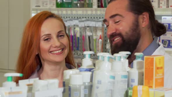 Handsome Bearded Pharmacist Giving His Female Customer Requested Product alt