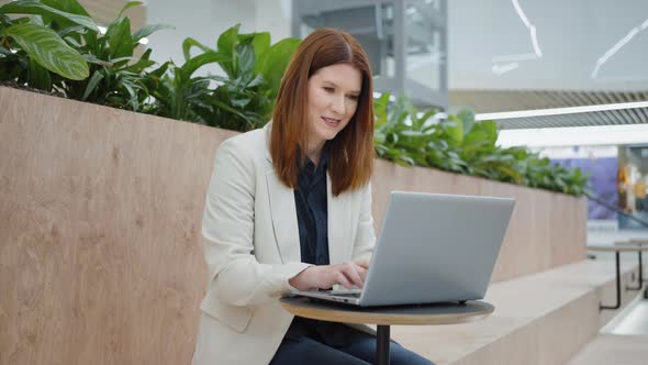 Businesswoman Chatting Online on Laptop in Cafe alt