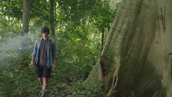 Asian Man Trekking In Forest alt