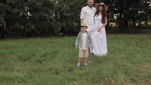 Little Boy Spending Time with His Mother and Father Outdoors