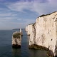 Drone flying between stack and rocky cliff wall of Old Harry Rocks, Dorset. Aerial approach - VideoHive Item for Sale