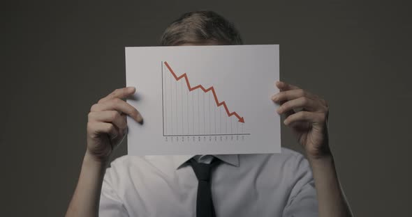 Businessman holding a negative financial chart