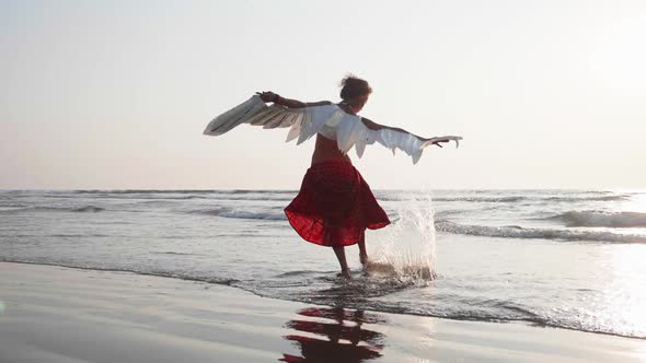 Young Girl with Angel Wings Dancing at Sunset