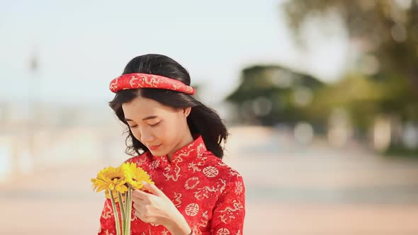 Beautiful Vietnamese Girl in Red Traditional Dress Ao Dai with Yellow Flowers alt