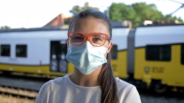 Portrait of Young Woman Waiting Train with Protective Mask at Face. Close-up. Travel, Tourism During alt