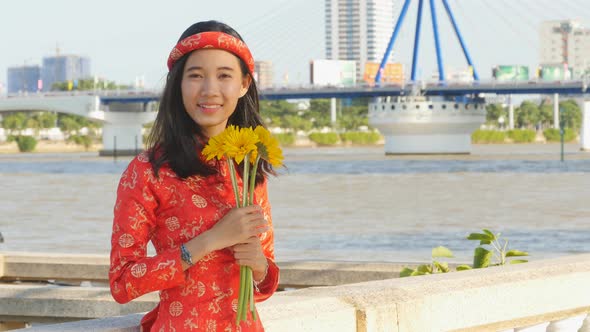 Beautiful Vietnamese Girl in Red Traditional Dress Ao Dai with Yellow Flowers alt