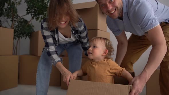 Excited Time for a Beautiful Family Dad and Mom Playing with the Small Boy in the New House Enjoying alt
