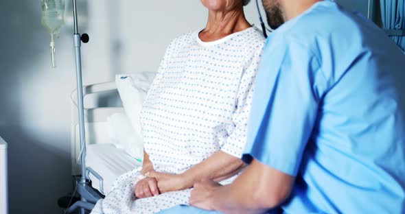 Nurse having a converstaion with smiling female senior patient alt