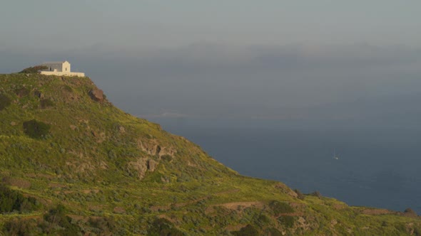 Flying Towards Church on Top of a Cliff and Tilt Down to Kilma Village Milos alt