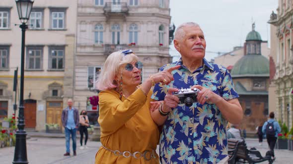 Senior Old Stylish Tourists Man Woman Walking Taking Photos on Old Camera at Summer City Center alt