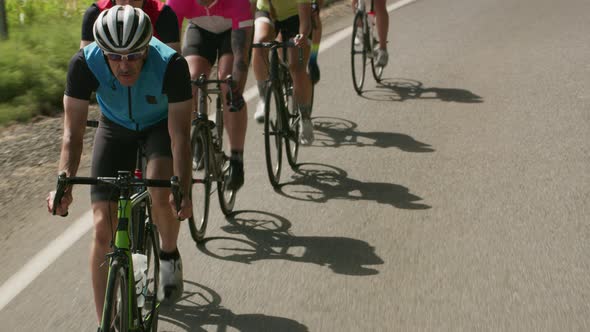 Tracking shot of a group of cyclists on country road.  Fully released for commercial use.