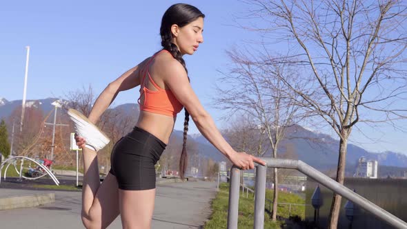 Beautiful Hispanic woman with long braid doing leg quad stretch alt