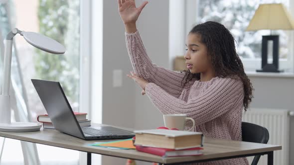 Side View of Inspired Intelligent African American Teenage Girl Raising Hand Answering Question on alt