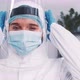 Happy Female Virusology Expert Doctor Posing in Disposable Medical Suit Mask and Shield Against - VideoHive Item for Sale