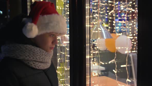 Boy in Santas Hat Looking in Shop Window